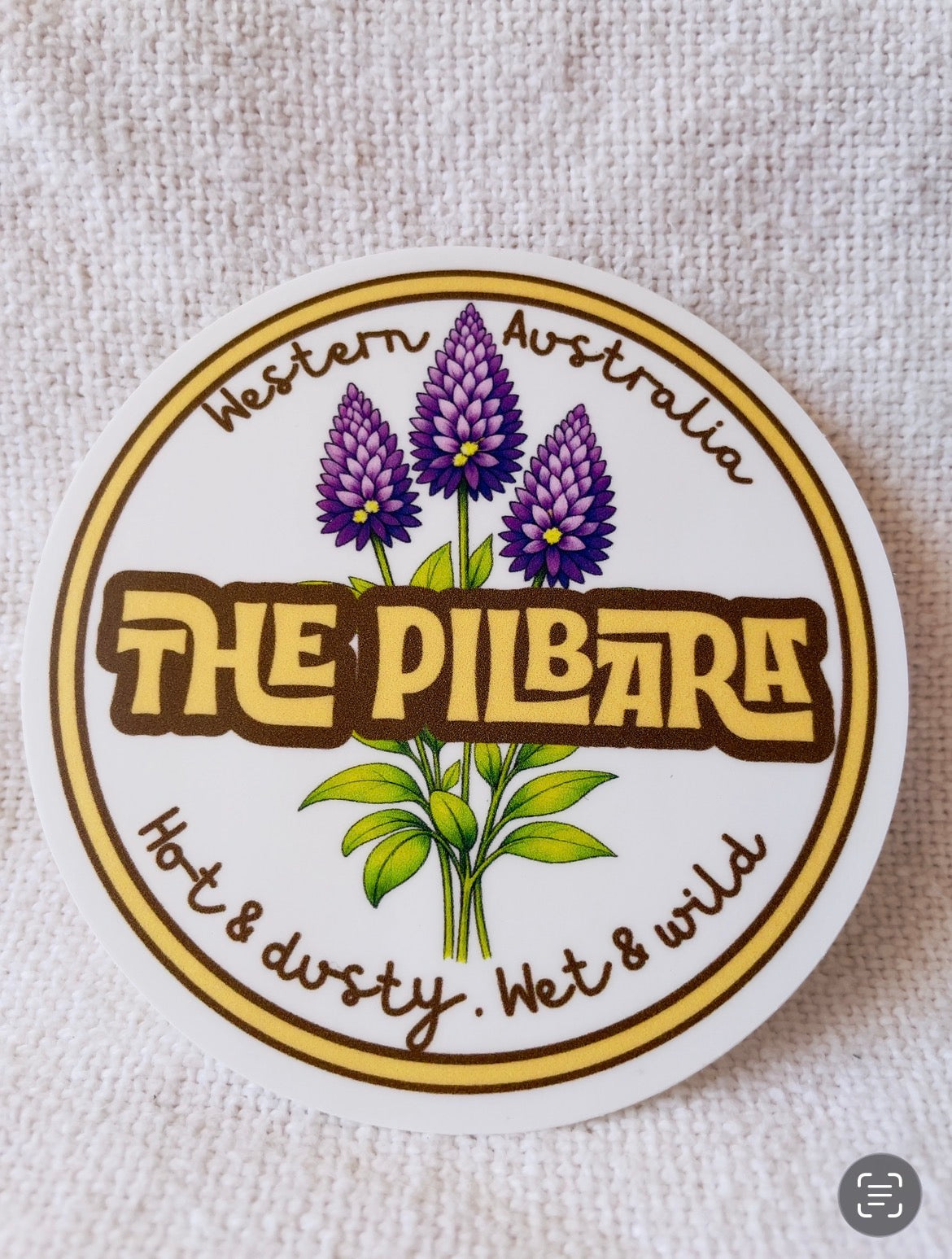 Round sticker with purple flowers and text 'The Pilbara, Western Australia' 
