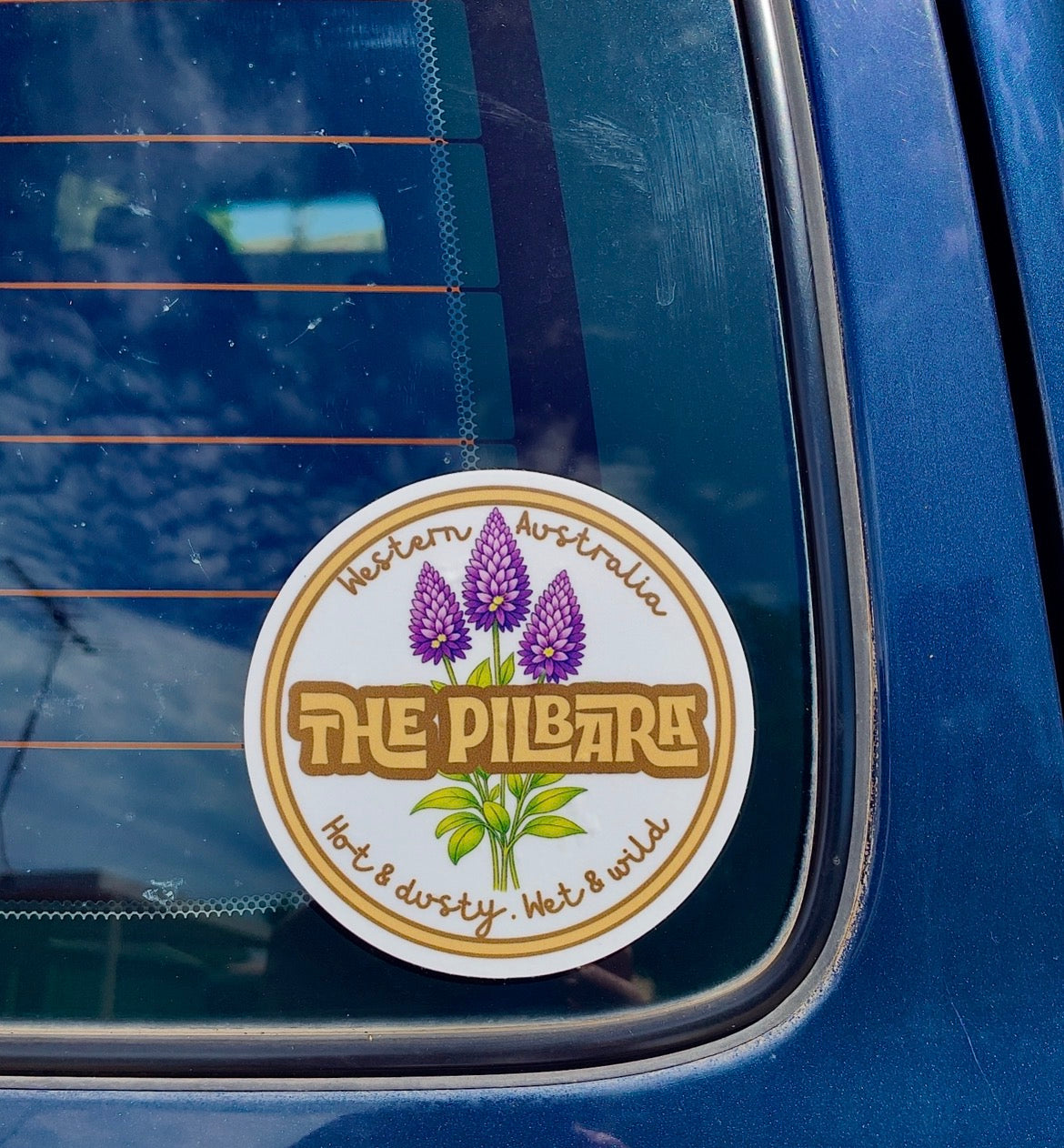 Sticker with mulla mulla floral design and The Pilbara on a blue car window